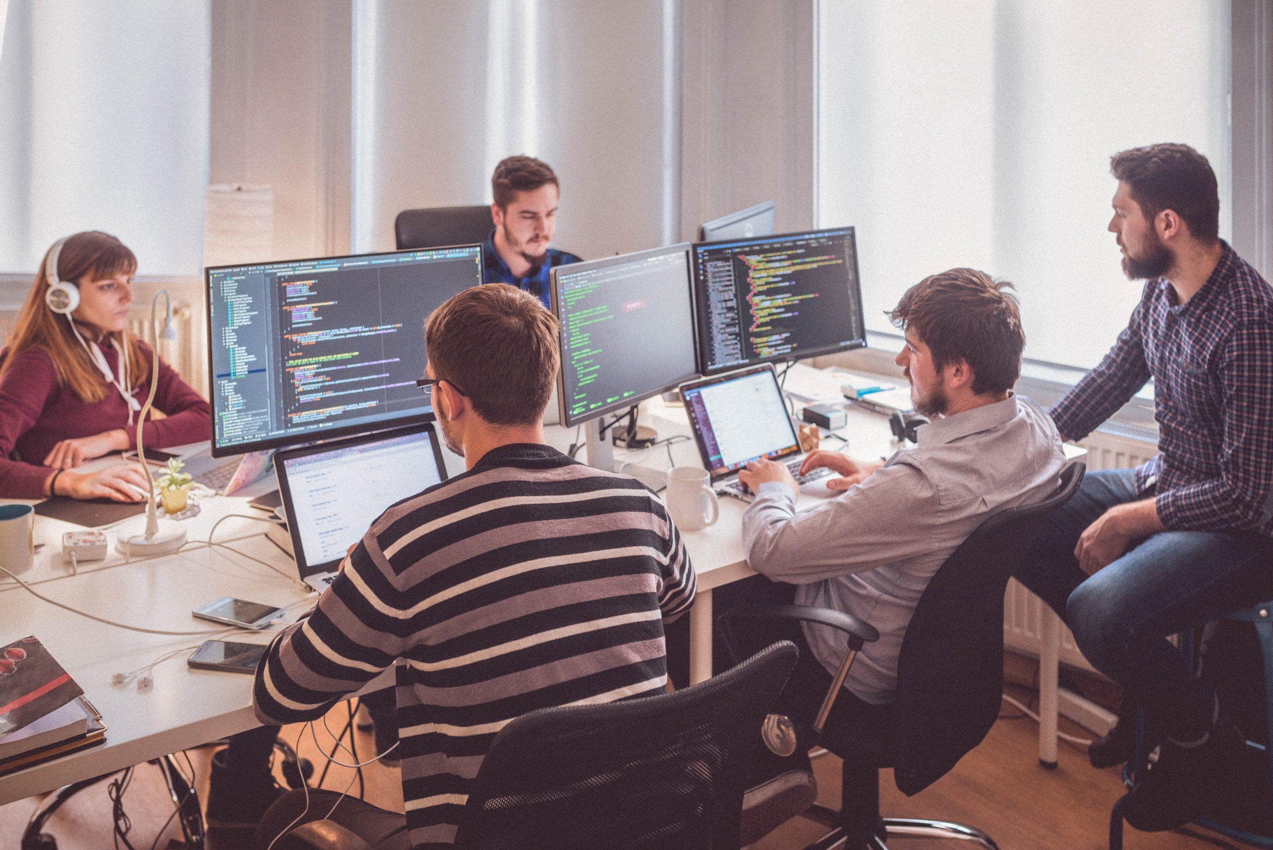Development team working on web application code in a modern office